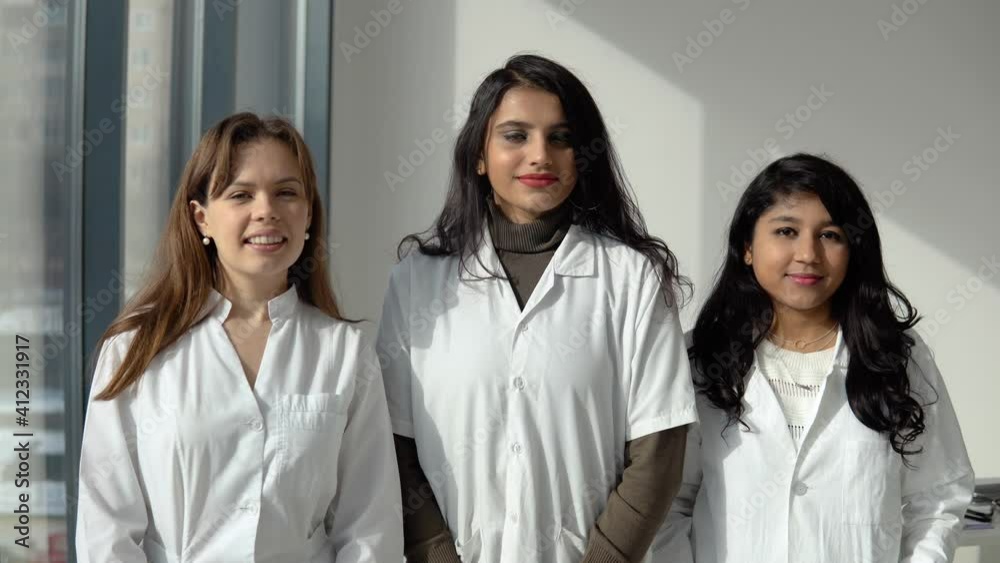 Three young women doctor of different nationalities look into the camera Three young women doctor of different nationalities look into the camera