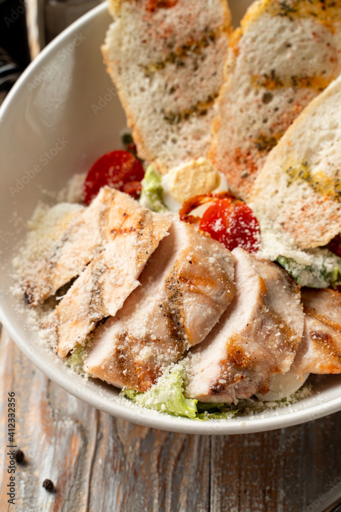 Caesar chicken salad with grilled crunchy croutons and mayo sauce, close up, advertisement photo