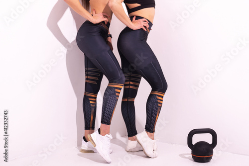 Female sportswear clothes on perfect body, Sneakers and blue leggings pants.