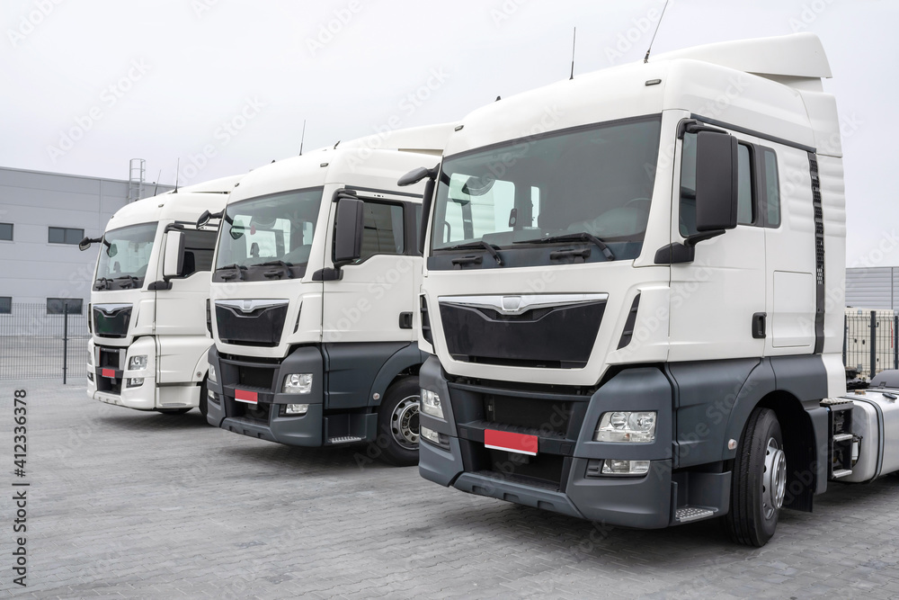 Trucks parked in a parking lot in a row. Automobile transportation. Logistics and transport, close-up