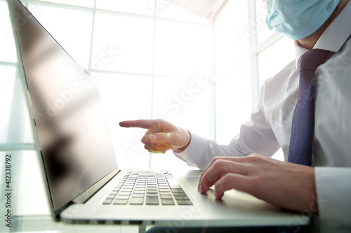 Businessman professional working hard in spacious bright office points with hand at laptop screen