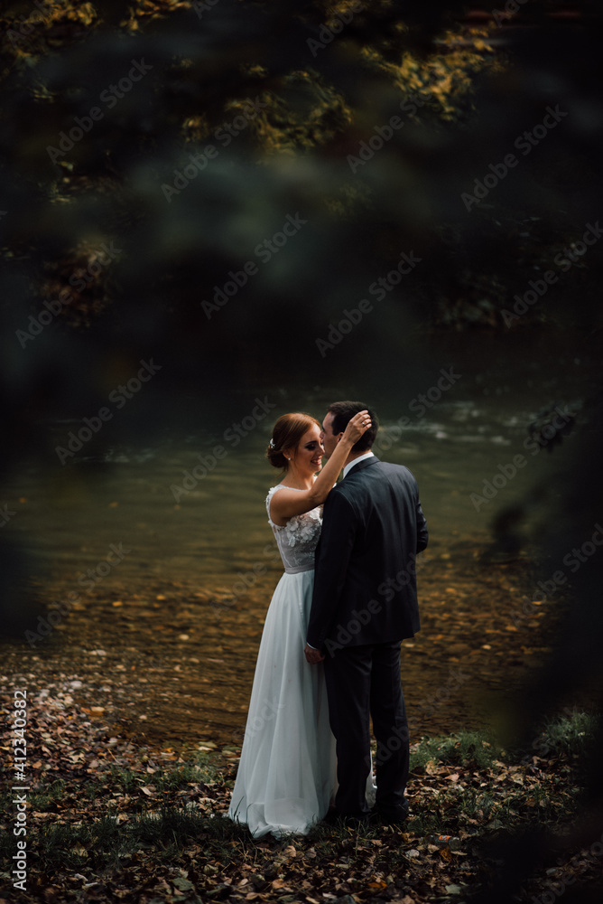 Beautiful married couple standing together by the lake Beautiful married couple standing together by the lake