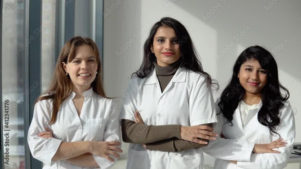 Medical students interns of different nationalities look into the camera and show a sign of approx. Doctors team Medical students interns of different nationalities look into the camera and show a sign of approx. Doctors team