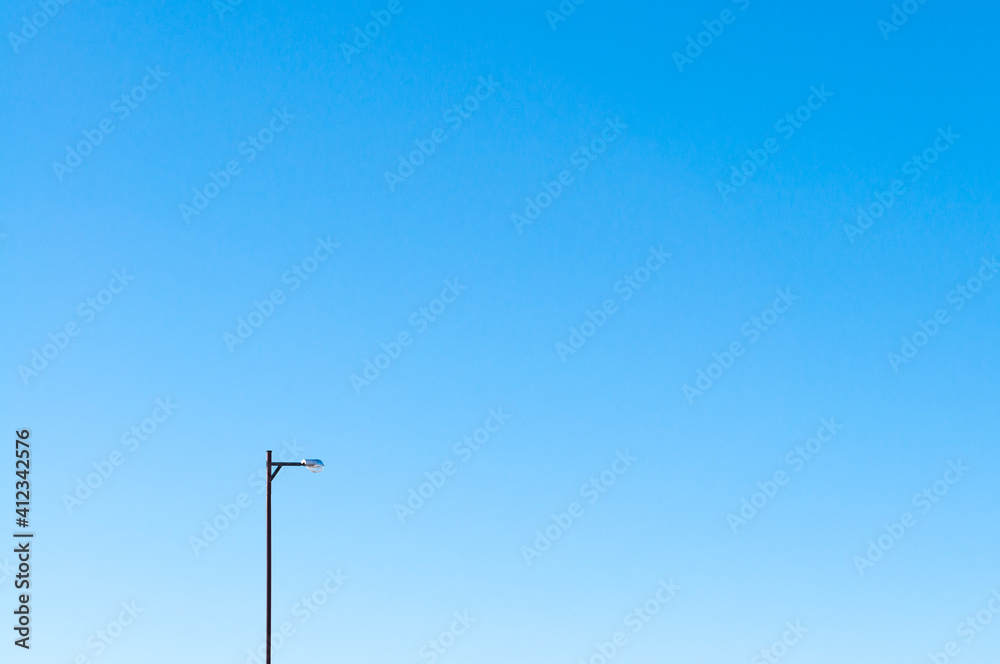 A lone street lamp against the blue sky A lone street lamp against the blue sky