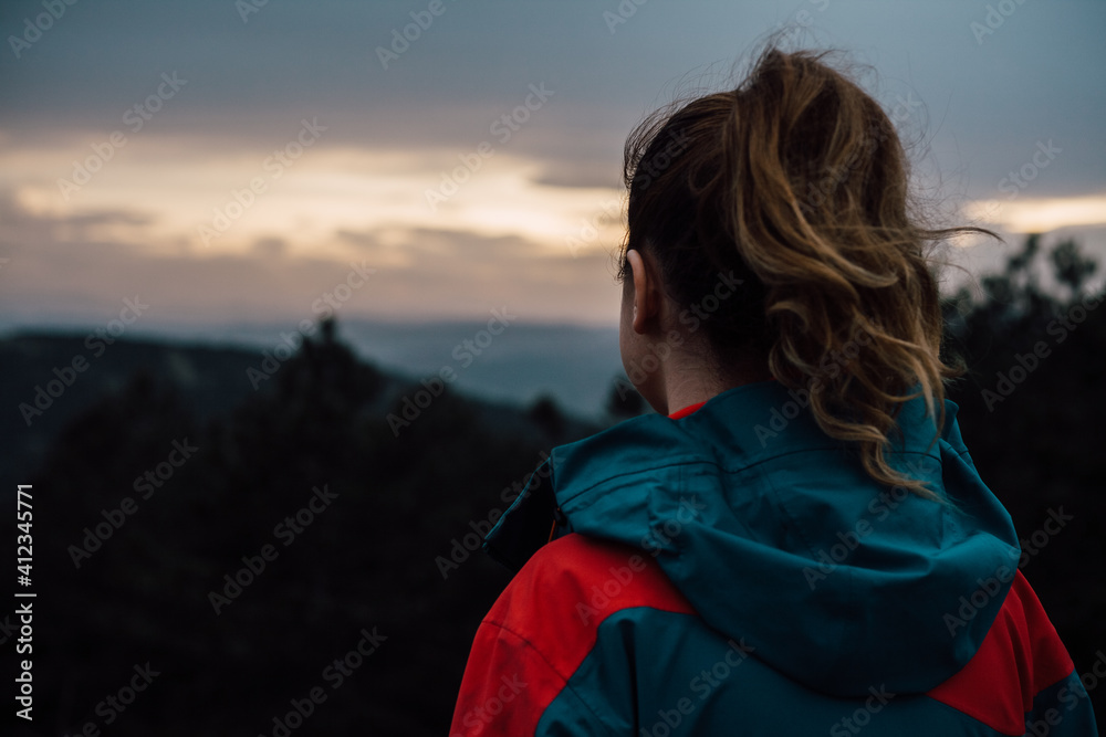 Woman watching sunset above the mountains