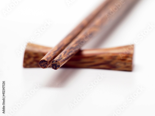 Close up shoot of a pair of wooden chopsticks on a white isolated background
