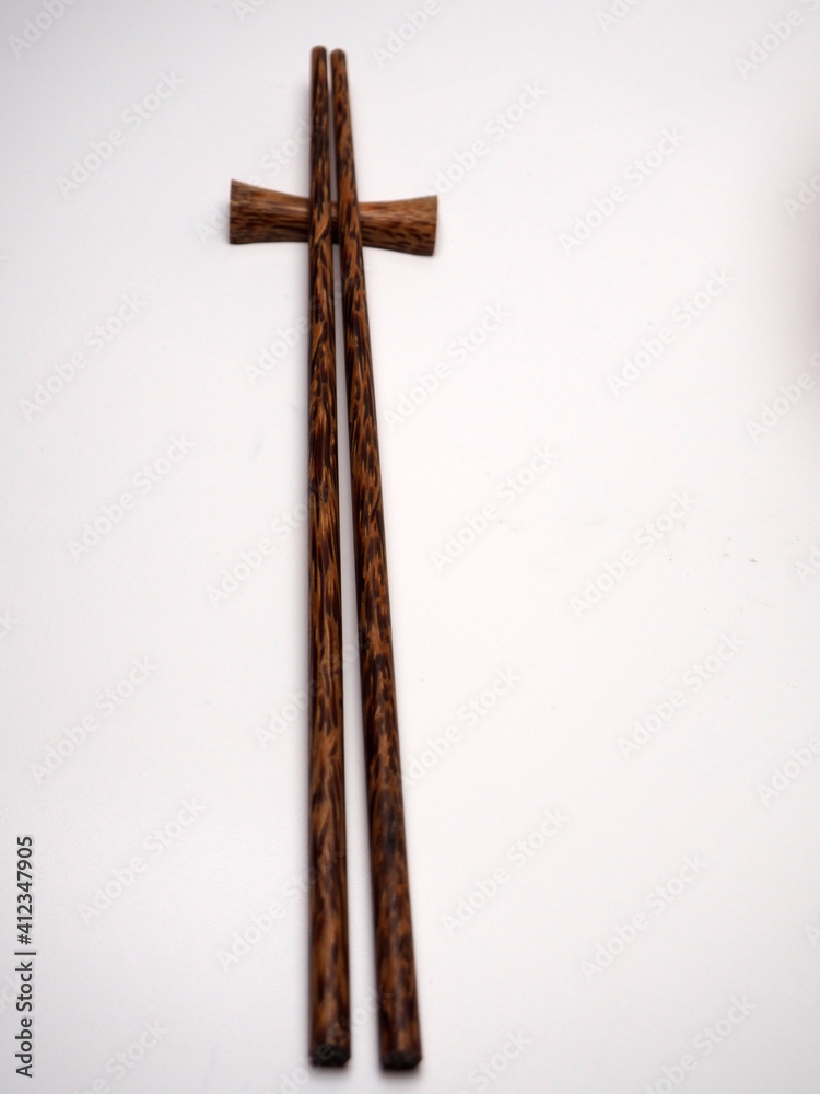 Close up shoot of a pair of wooden chopsticks on a white isolated background