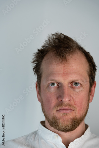 Close up portrait of a man where he is angry looking forward through his forehead and hair is drilled