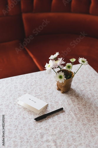 Card next to flowers on a table photo