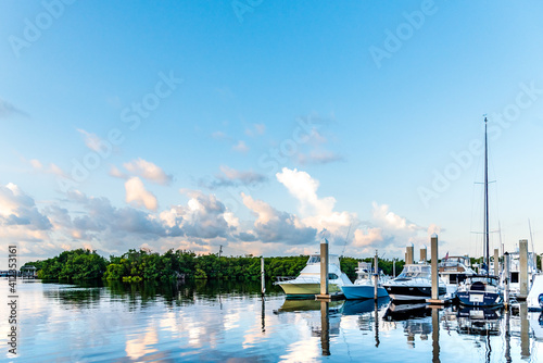 Boats docked in the marina on a beautiful calm day at Matheson Hammock Marina in Miami.