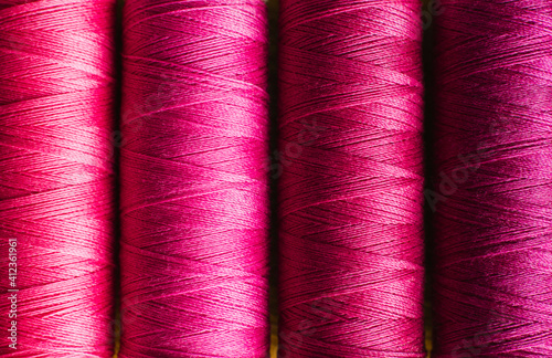 Close up spools of purple hued cotton thread photo