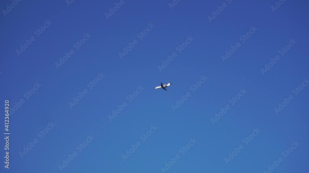 Airplane flying away against a blue sky background
Airplane flying away against a blue sky background