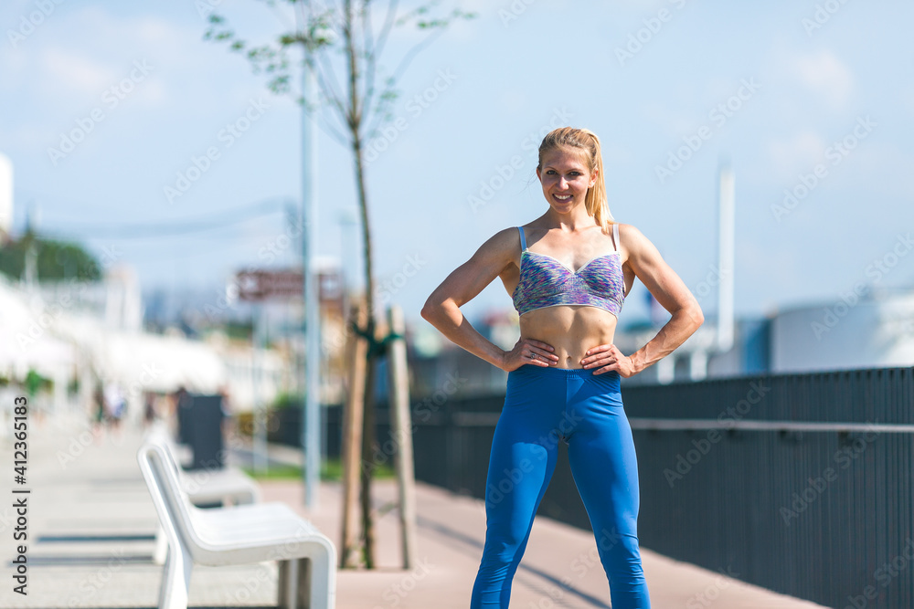 fit and muscular woman standing on the promenade