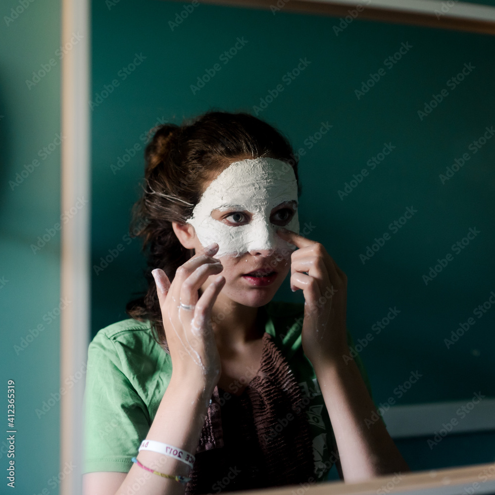 teen girl creating a mask/masquerade (in mirror) teen girl creating a mask/masquerade (in mirror)