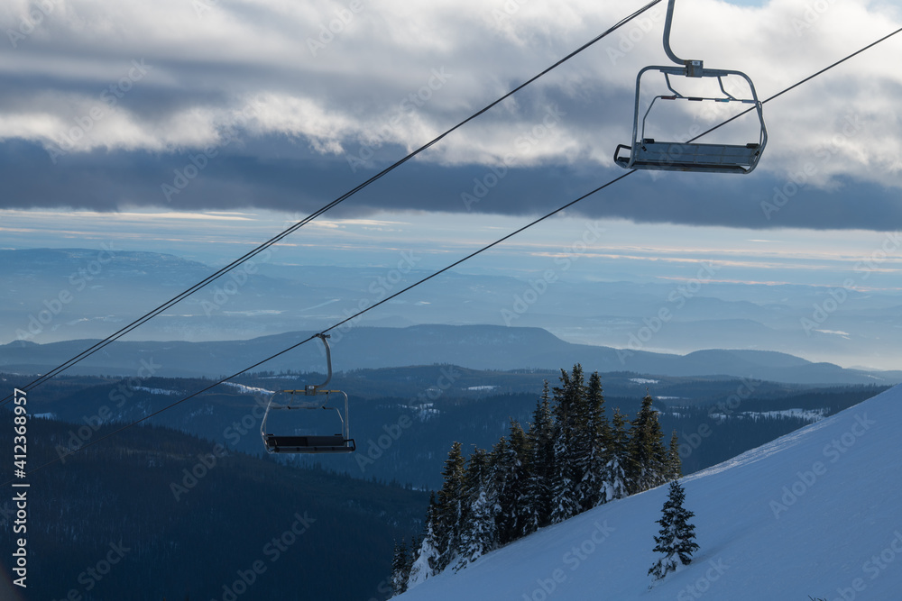 empty chair lift chairs on ski resort in winter with ski runs in background on cold temperature day no people nobody at the hill empty chair lift chairs on ski resort in winter with ski runs in background on cold temperature day no people nobody at the hill