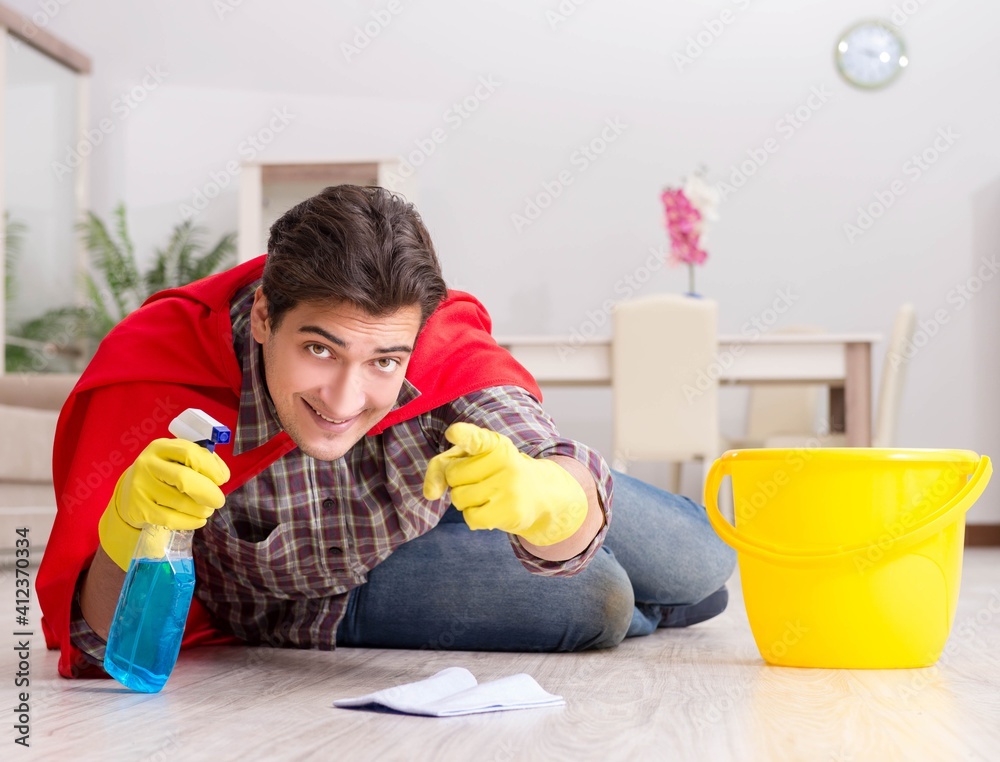 Super hero husband cleaning floor at home