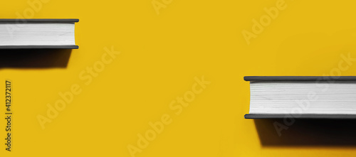 two books in gray hardcover with white blank sheets with hard trend shadow on bright Illuminating yellow background, book day 2021 concept, colors of year application, selective focus