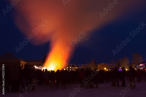 Slow shutter crowd of people around a bonfire at night