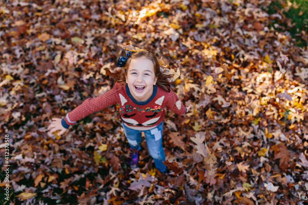 Cute young girl having fun playing with fallen leafs Cute young girl having fun playing with fallen leafs