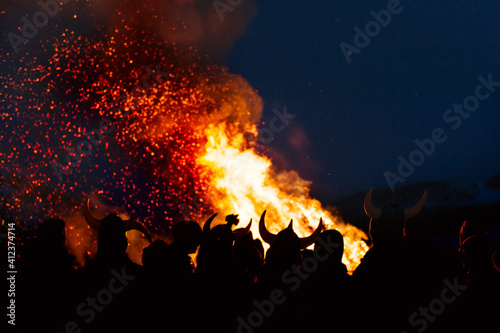 A crowd of people around a bonfire at night photo