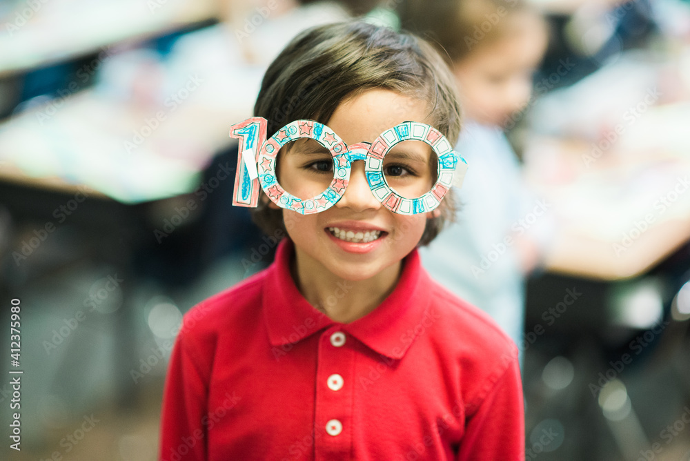 child wearing paper glasses in the shape of the numeral 100 for a celebration of the 100th day of school child wearing paper glasses in the shape of the numeral 100 for a celebration of the 100th day of school