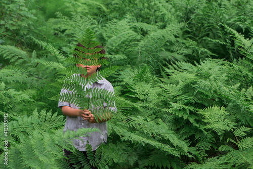 young child surrounded by ferns