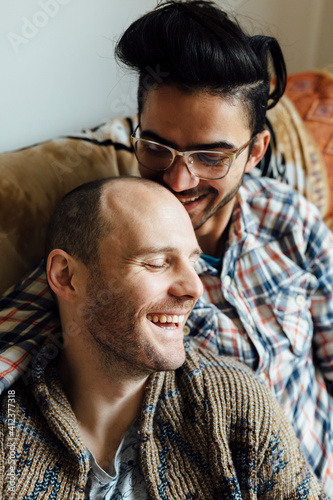 Young Gay couple Realxing on the Couch of the Living Room Watchi photo