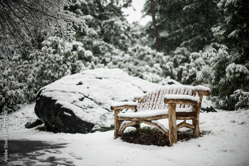 Snow falling on a bench photo