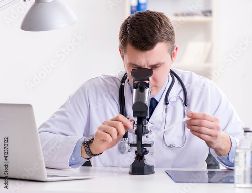 Male doctor looking at lab results in hospital