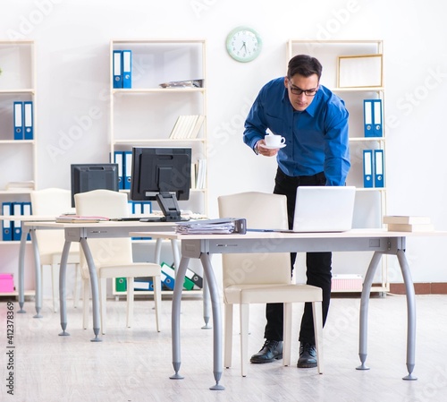 Handsome businessman employee sitting at his desk in office