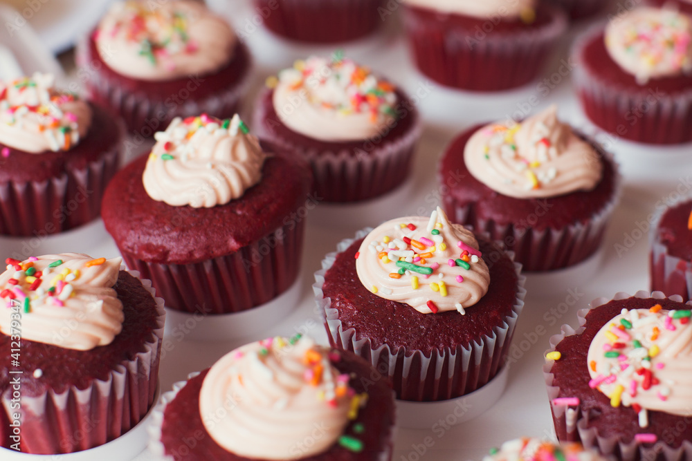 red velvet cupcakes with icing and colored sprinkles red velvet cupcakes with icing and colored sprinkles