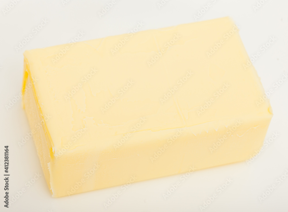 Piece of tasty fresh butter on white background..