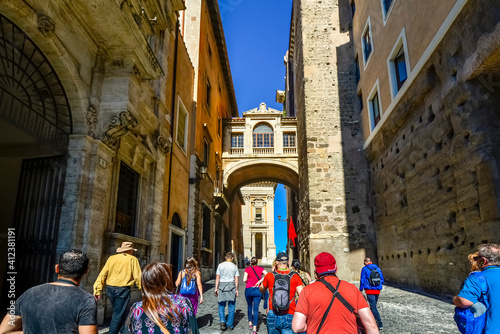 A group of unidentifiable tourists follow a tour guide  through Capitoline Hill and the Portico dii Consentes near the Roman Forum in Rome Italy photo