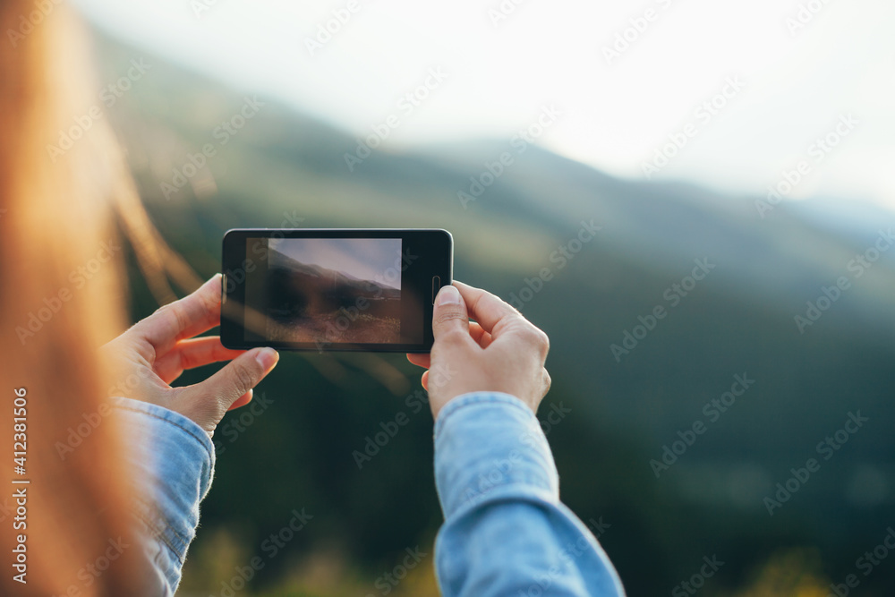 Young woman using smart phone to take photos of a beautiful landscape. Young woman using smart phone to take photos of a beautiful landscape.