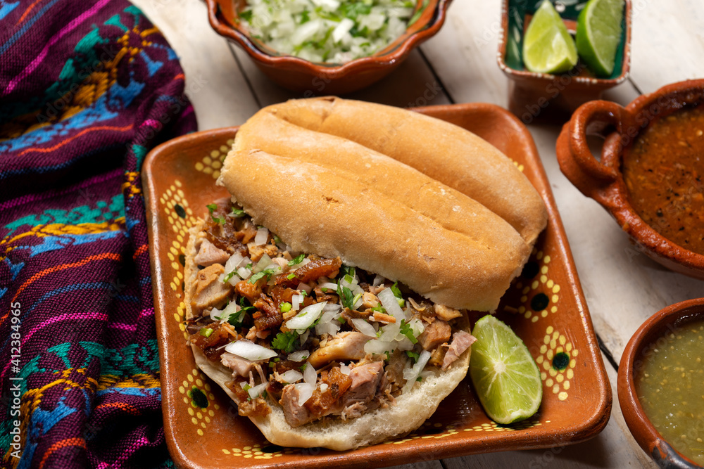 Confit pork sandwich called Torta de carnitas on white background