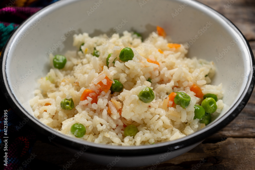 White rice with peas and carrot on wooden White rice with peas and carrot on wooden