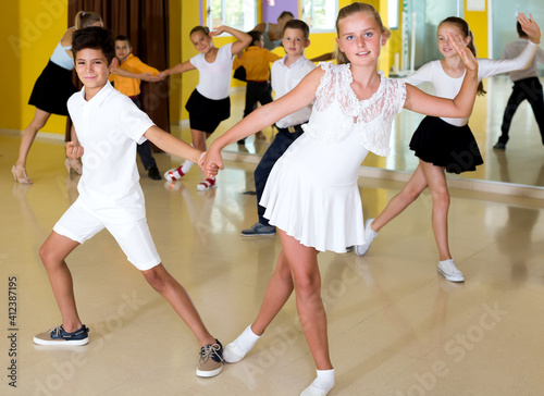 Beautiful boys and girls enjoying active dance in studio