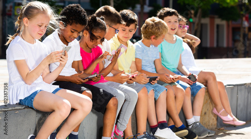 Children are playing on smartphone in the playground. High quality photo