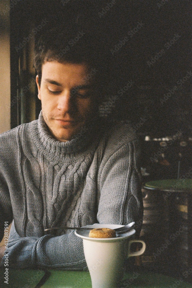 Image from analog camera of a young man in the cafe drinking tea Image from analog camera of a young man in the cafe drinking tea