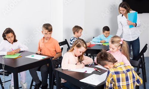 Group of children in elementary age at drawing lesson