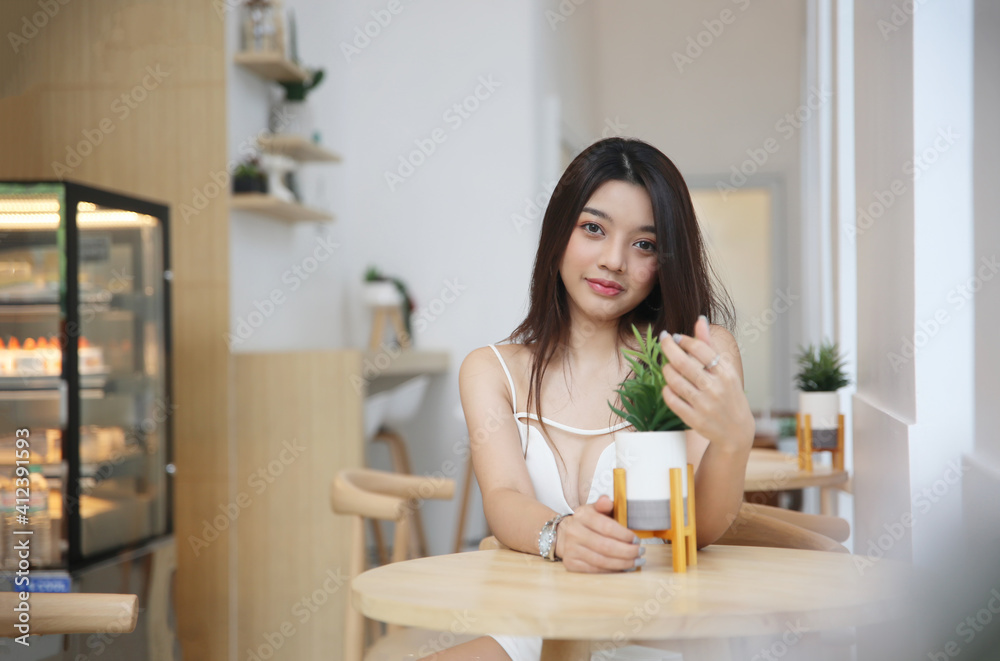 Portrait of Asian Young happy woman sitting alone in modern coffee shop interior. Portrait of Asian Young happy woman sitting alone in modern coffee shop interior.