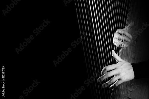Fényképezés Harp player. Hands playing Irish harp strings closeup