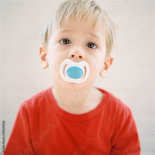 square portrait of a cute little boy with a pacifier photo