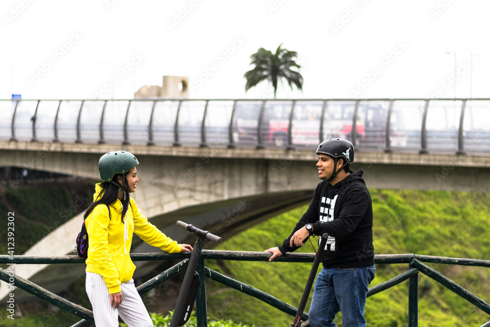 Two smiling friends showing helmet, concept in driving safety with a means of transportation