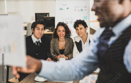 Selective focus on Attendee. African american men explaining the attendees snilling on a board, having graph papers at the conference room in the office. Concept meeting teamwork. photo