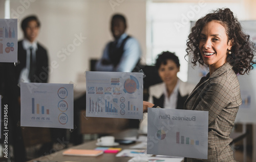 Selective focus on Businesswomen smilling explaining the attendees snilling and on a board, having graph papers at the conference room in the office. Concept meeting teamwork. photo