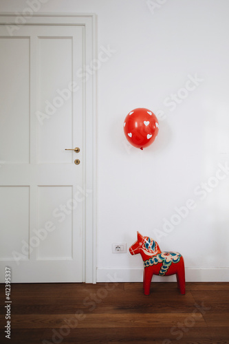 Red and white heart decorated balloon floating over original swedish decorated horse photo
