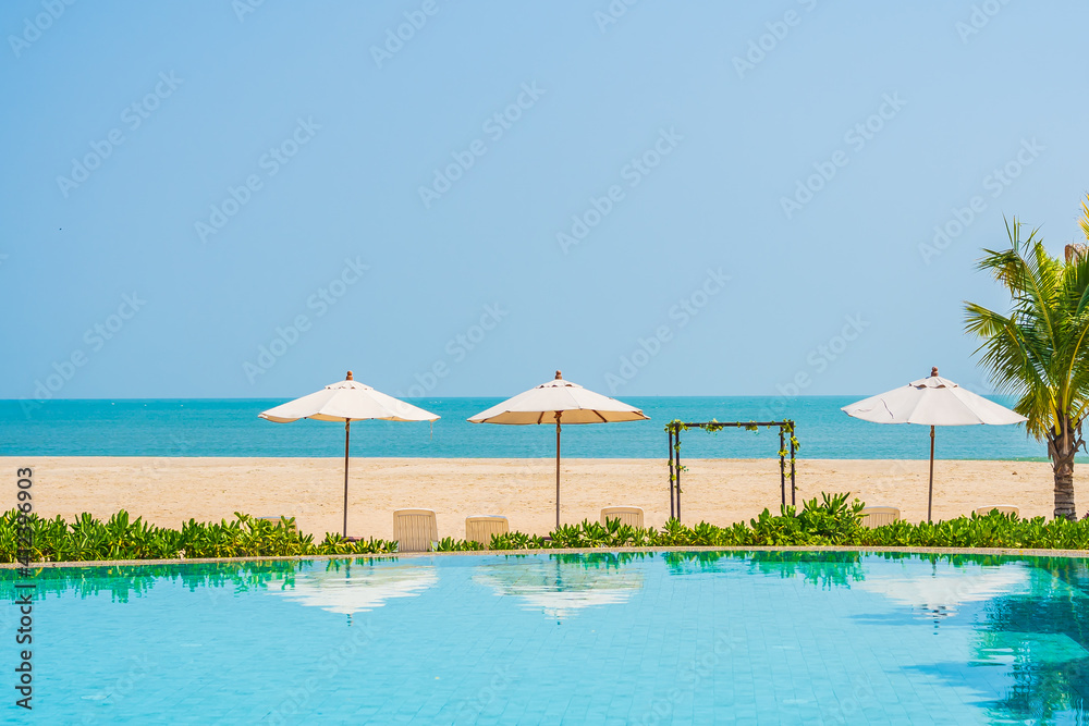 Fototapeta premium Umbrella and chair around outdoor swimming pool in hotel resort