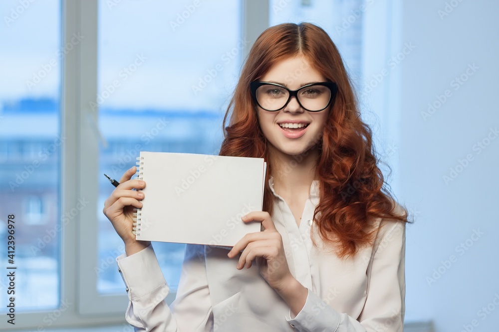 Business red-haired woman holding notepad in the hands of an official manager Business red-haired woman holding notepad in the hands of an official manager