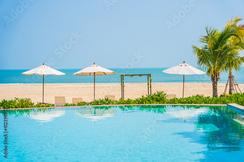 Umbrella and chair around outdoor swimming pool in hotel resort
